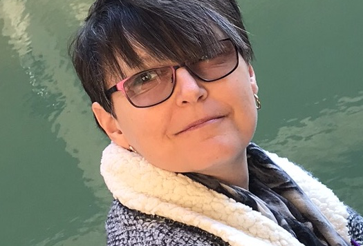 White female with glasses looks at camera