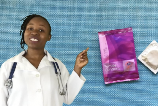 Black female in doctors outfit pints to animated condom
